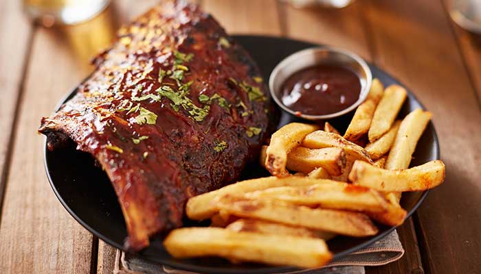 Barbecued ribs with fries and sauce, served fresh at our restaurant in Glyndon MN.