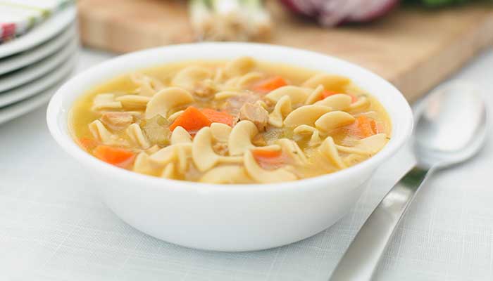 A white bowl of chicken noodle soup featured on the Restaurant Menu Glyndon MN.